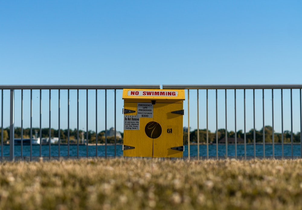 a yellow sign on a fence