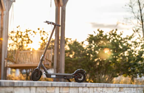 A sleek Kenwing electric scooter parked against a vibrant Nairobi mural under golden afternoon light