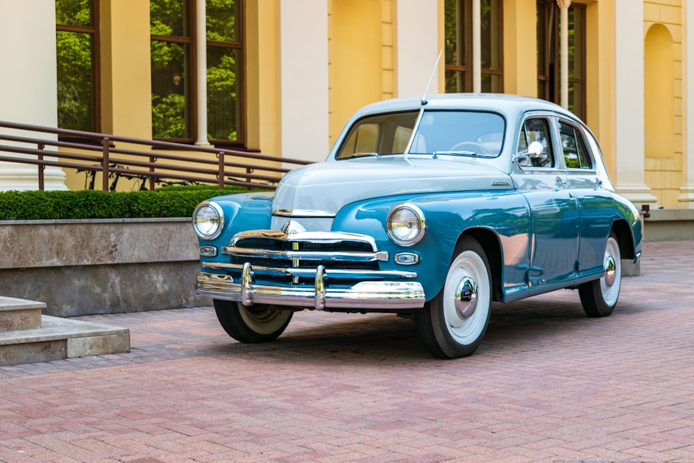 a blue car parked on a brick road