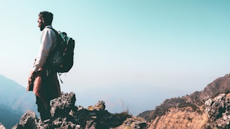 a man standing on top of a mountain with a backpack