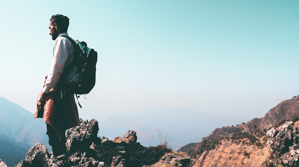 a man standing on top of a mountain with a backpack