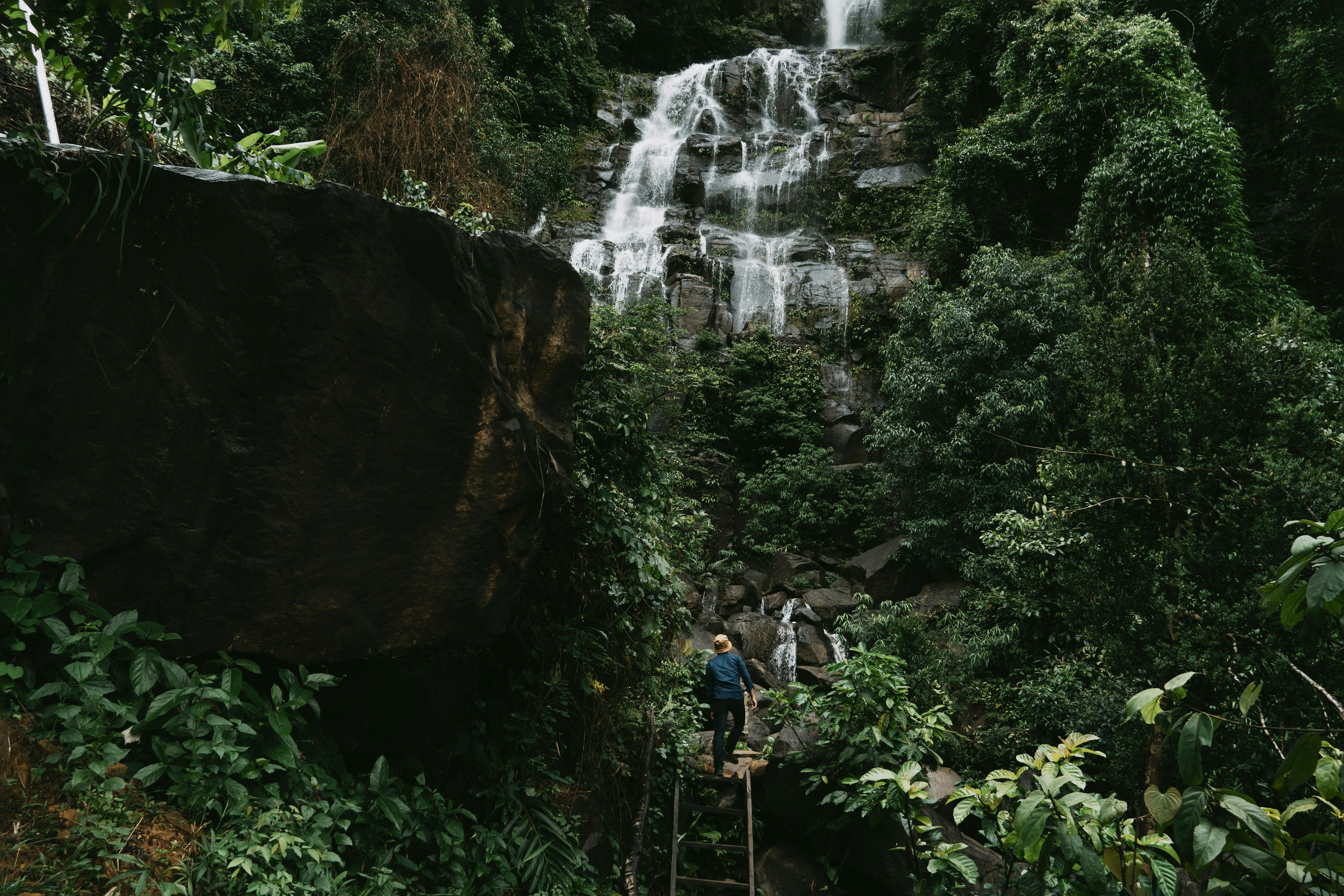 people standing on a rock ledge near a waterfall, 
