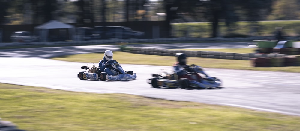 a pair of people racing go karts on a track