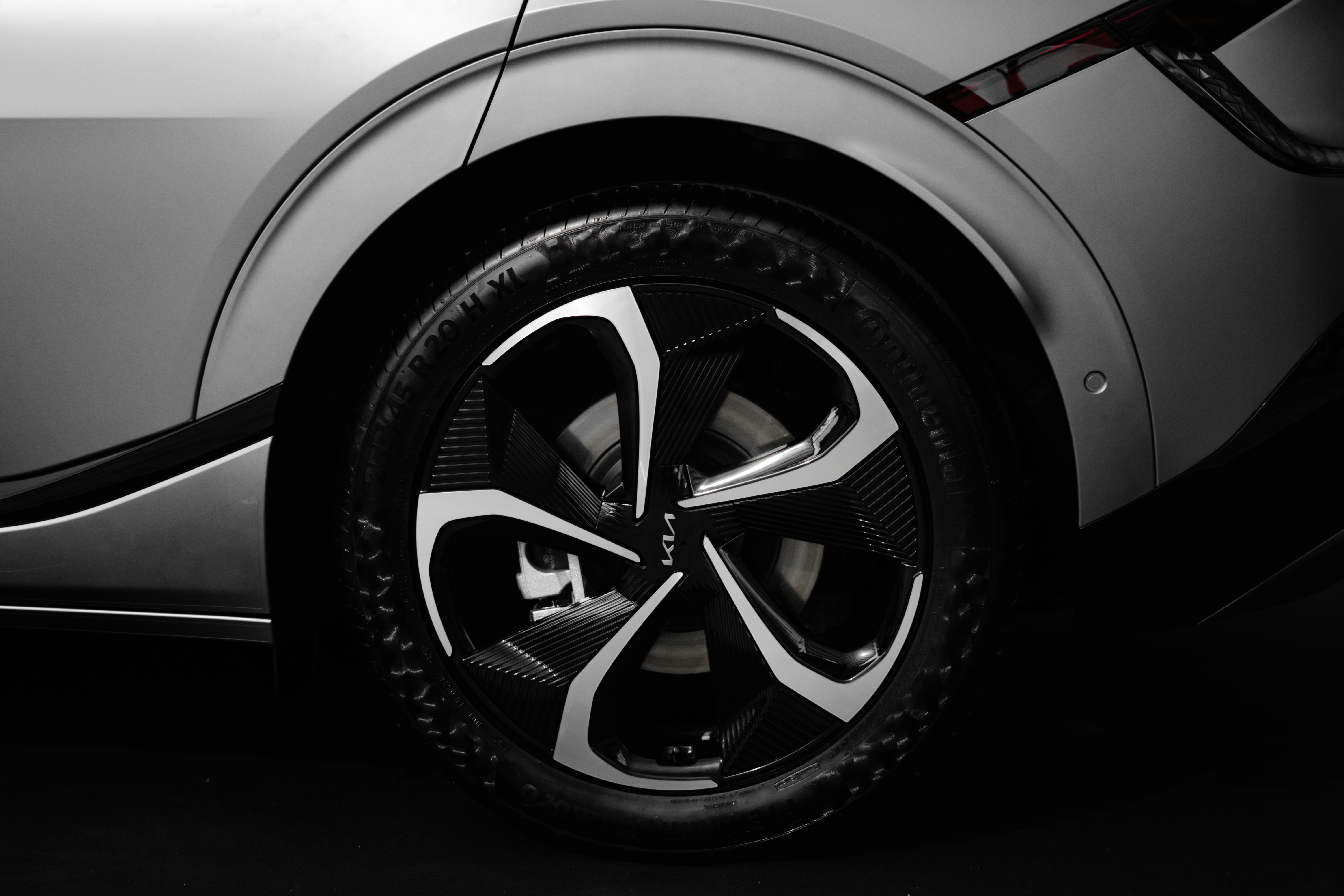 Used electric car parked with closeup of alloy wheel and tire tread