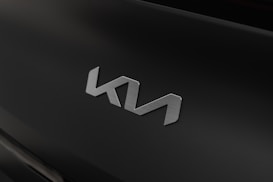 A sleek, metallic emblem with a modern design is displayed against a matte black background. The emblem appears to be the logo of a brand, possibly an automotive company.