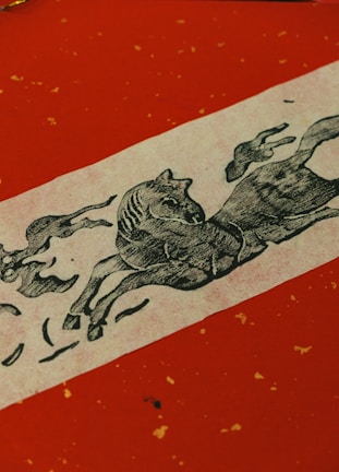 A vibrant red and gold illustration of a fiery horse galloping with Chinese lanterns glowing in the background.