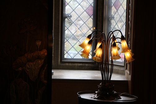 A beautifully restored Tiffany-style lamp glowing warmly in a cozy living room.