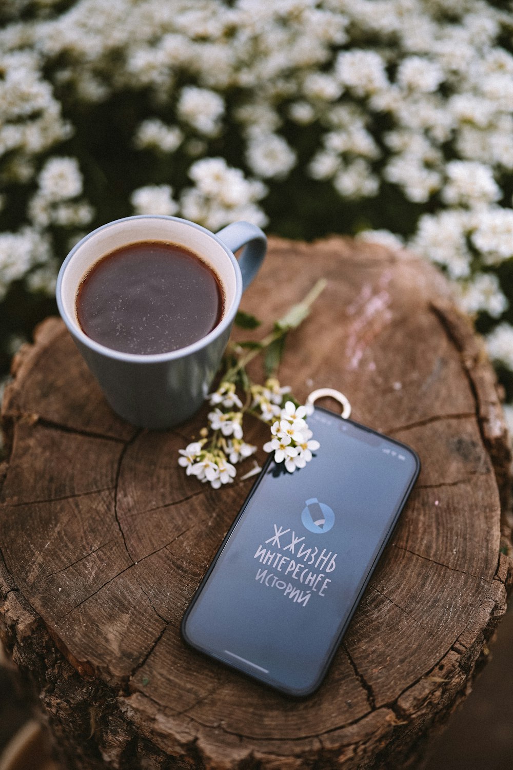 a cup of coffee and a book on a wood table