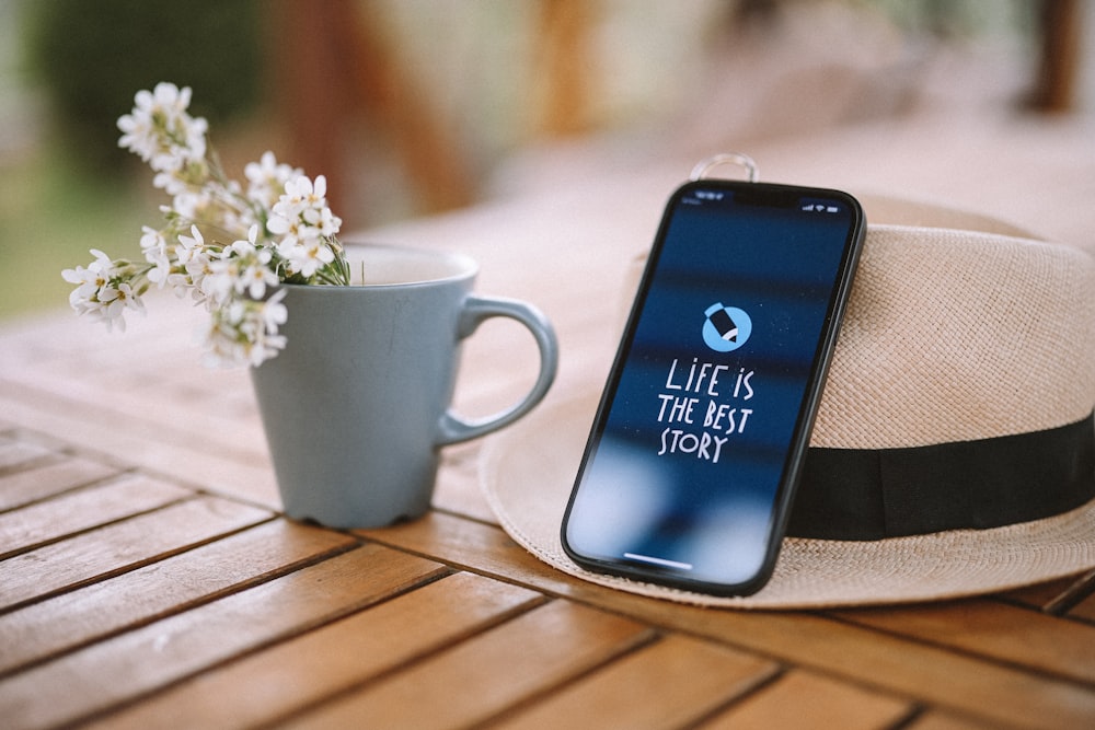 a cell phone and a cup of coffee on a table