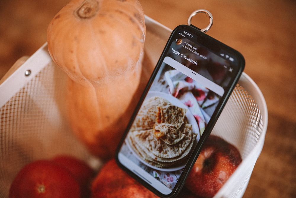 a cell phone next to a fruit