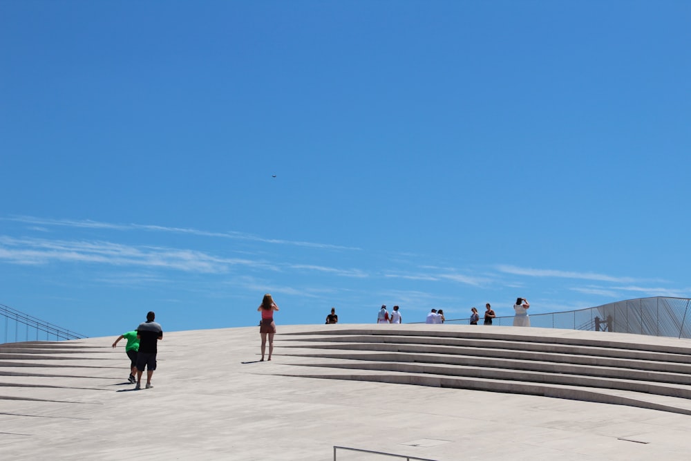 people walking on a concrete walkway