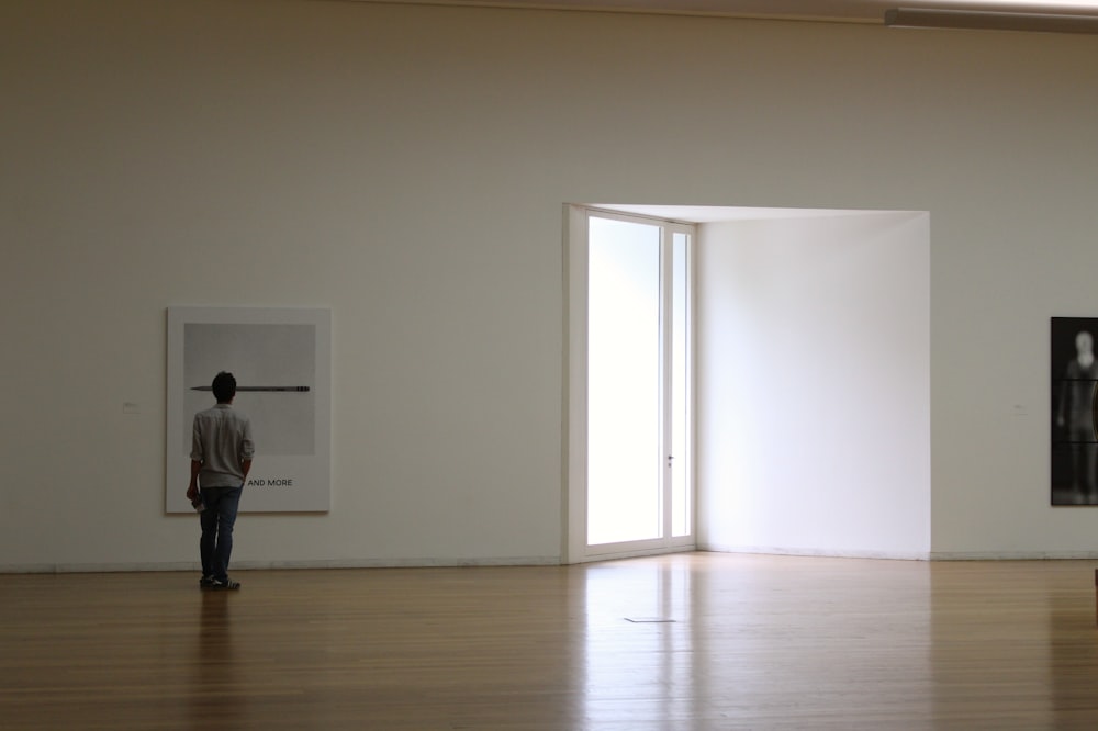 uma pessoa olhando para uma pintura na parede