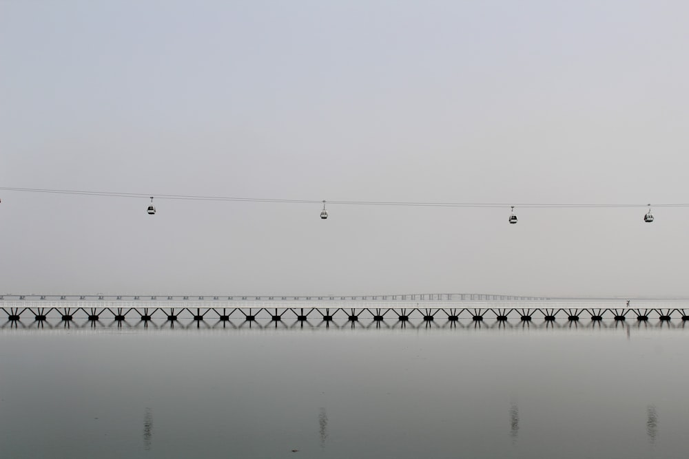 a group of birds flying over a bridge