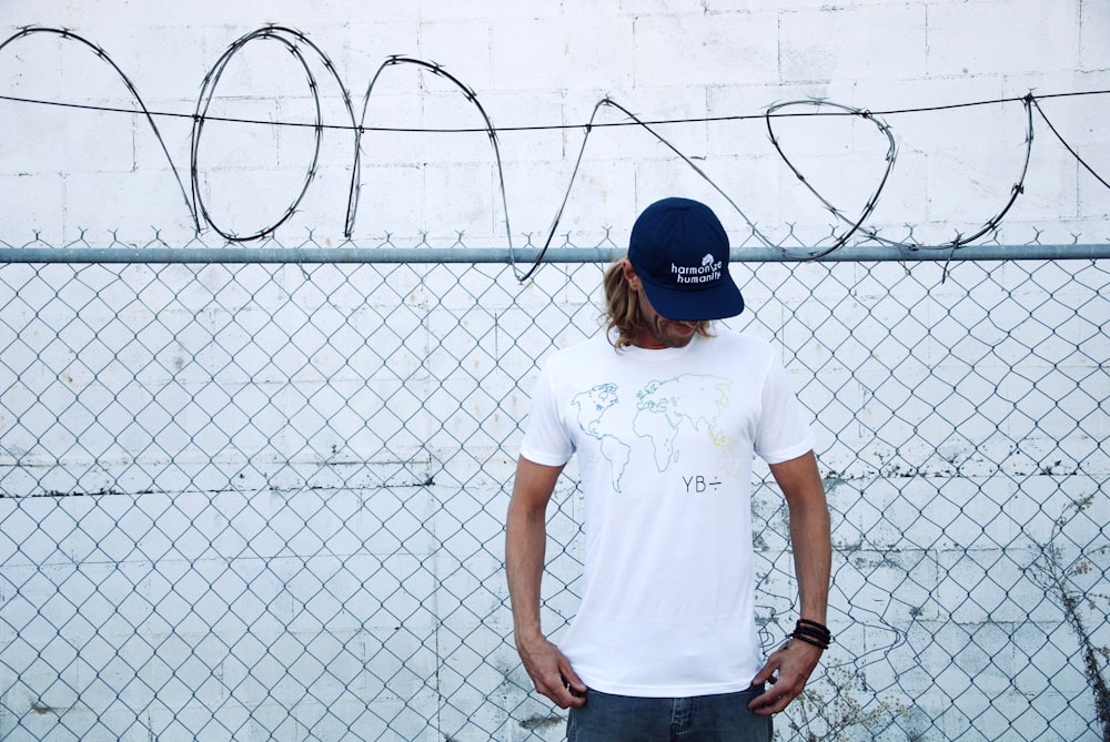 a person standing in front of a fence with a drawing on it