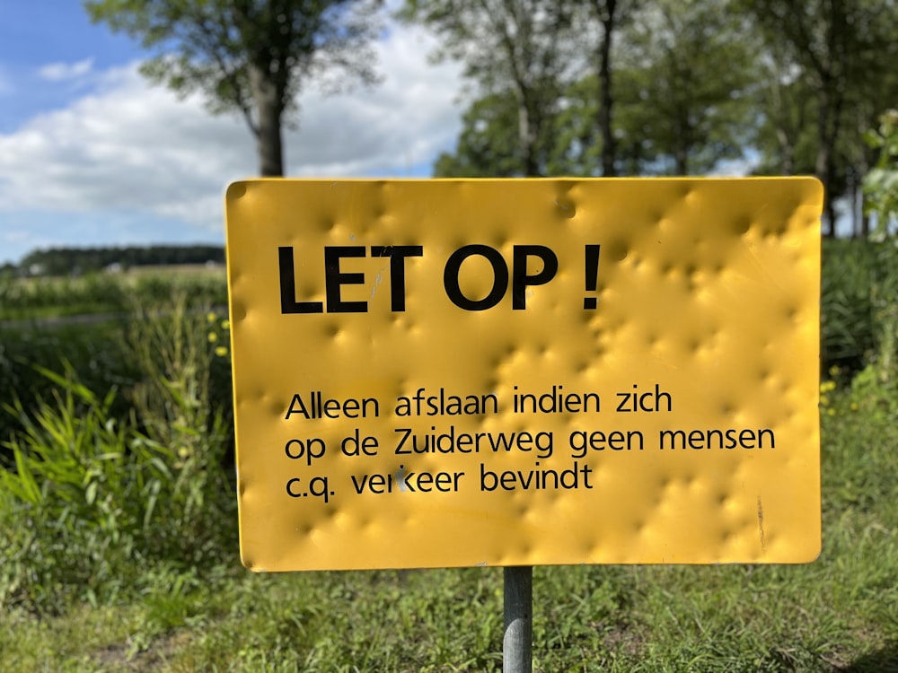 a yellow sign in a field