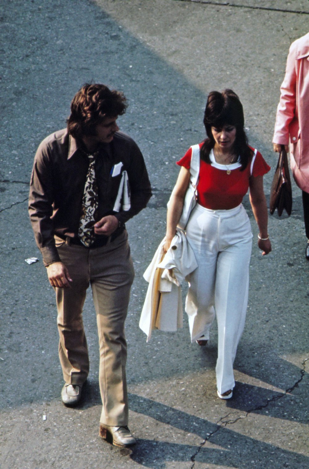 a man and woman walking down a sidewalk