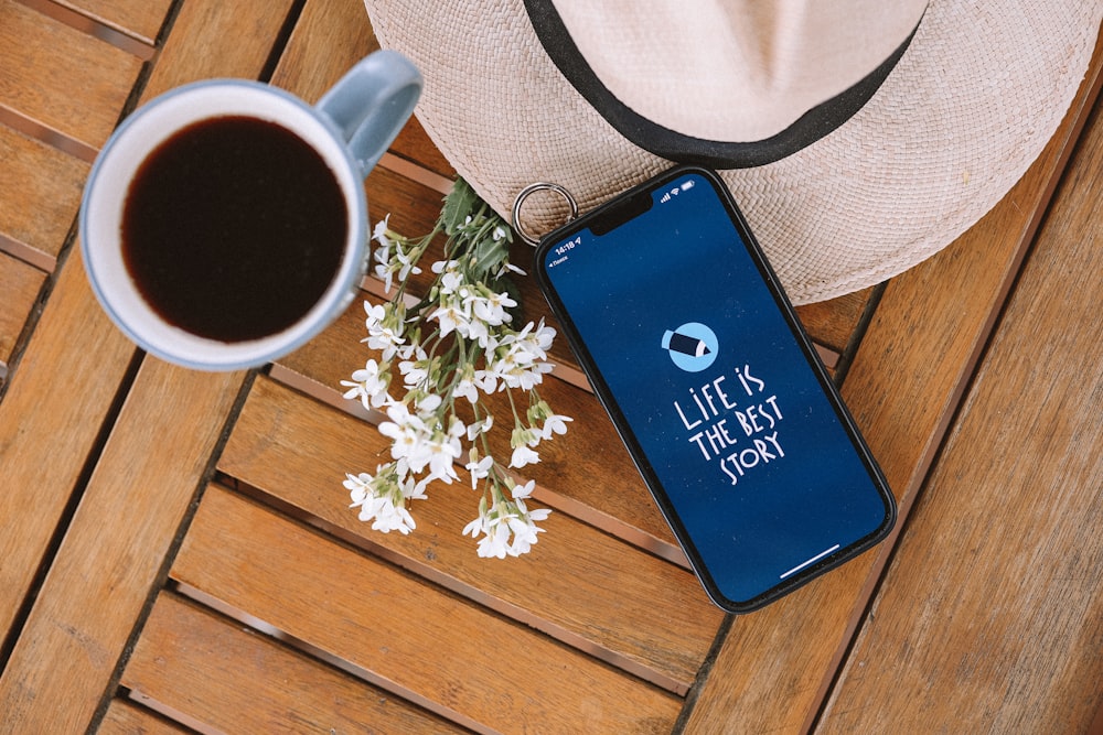 a cell phone and a cup of coffee on a table