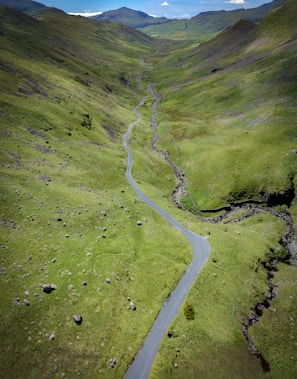 A winding road through a lush green valley.