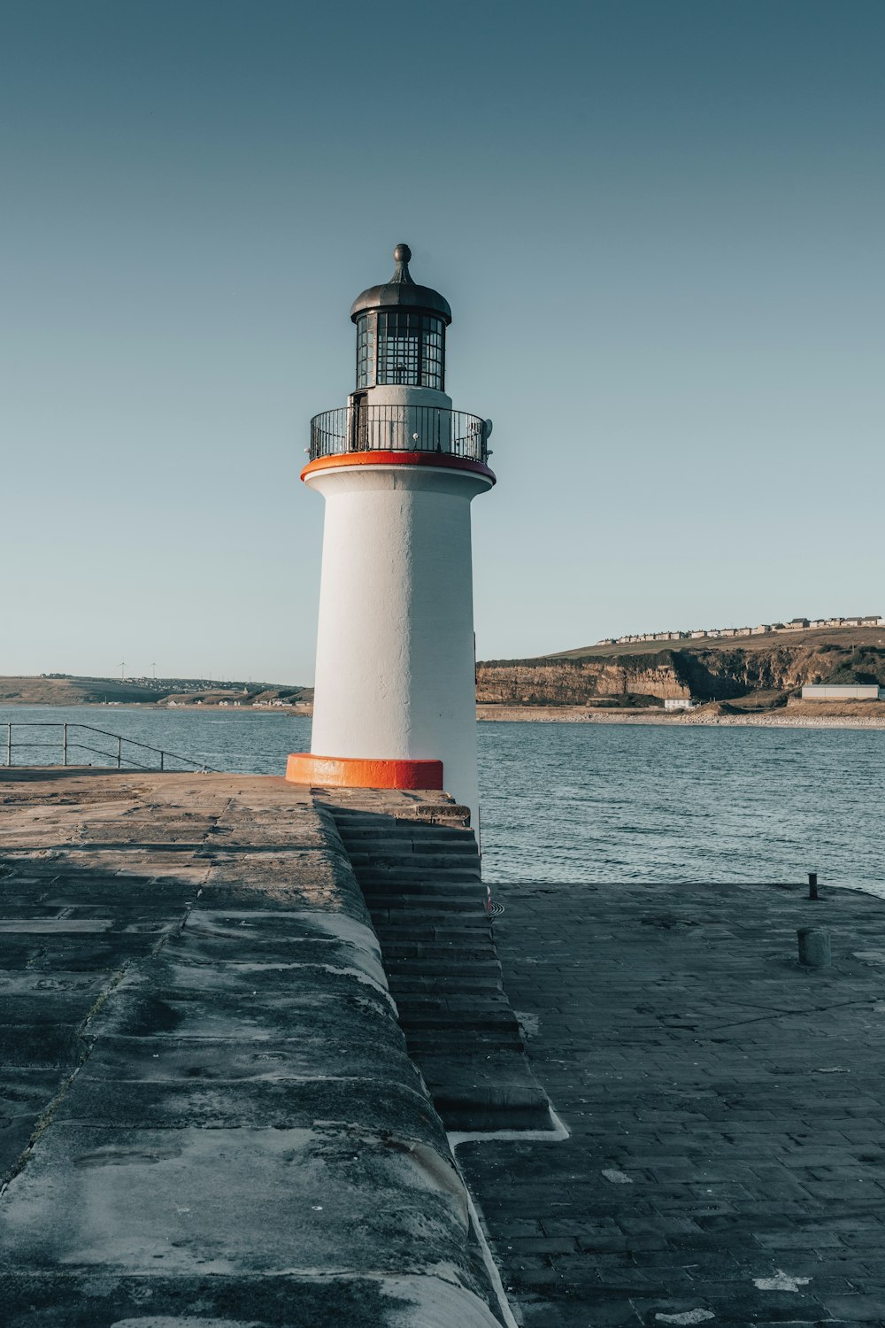 a lighthouse on a pier with Brant Point Light in the background