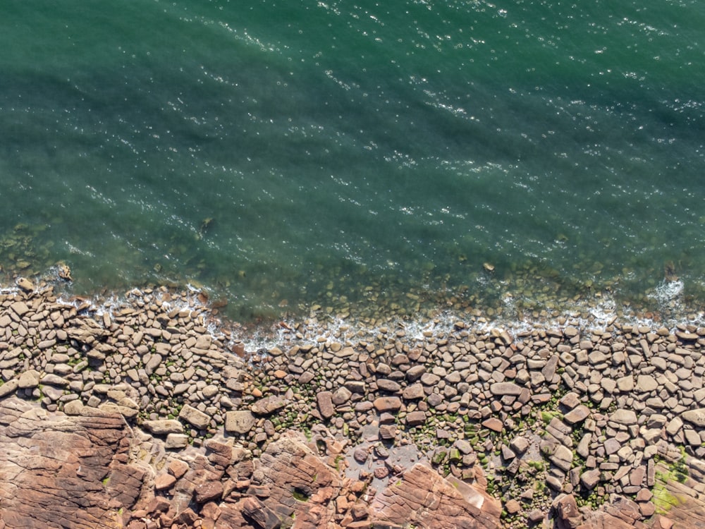 a rocky beach with water in the background