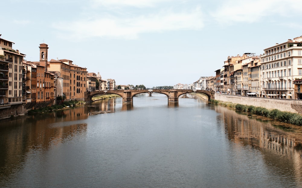 a river with a bridge and buildings along it