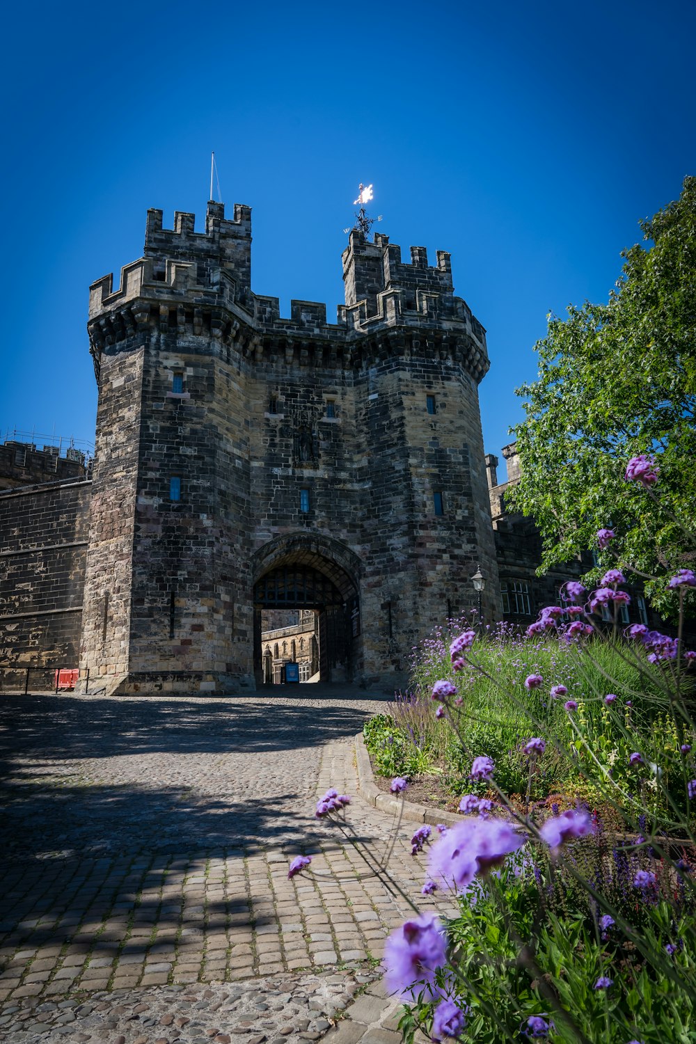 a stone castle with purple flowers