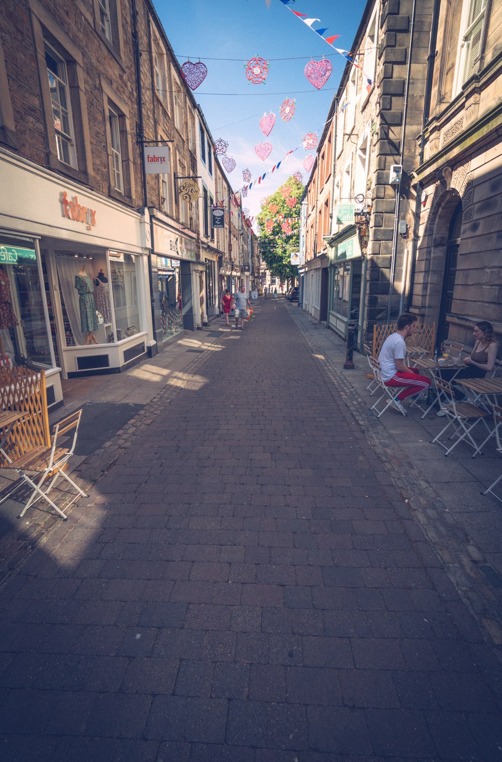 people sitting at tables in a street