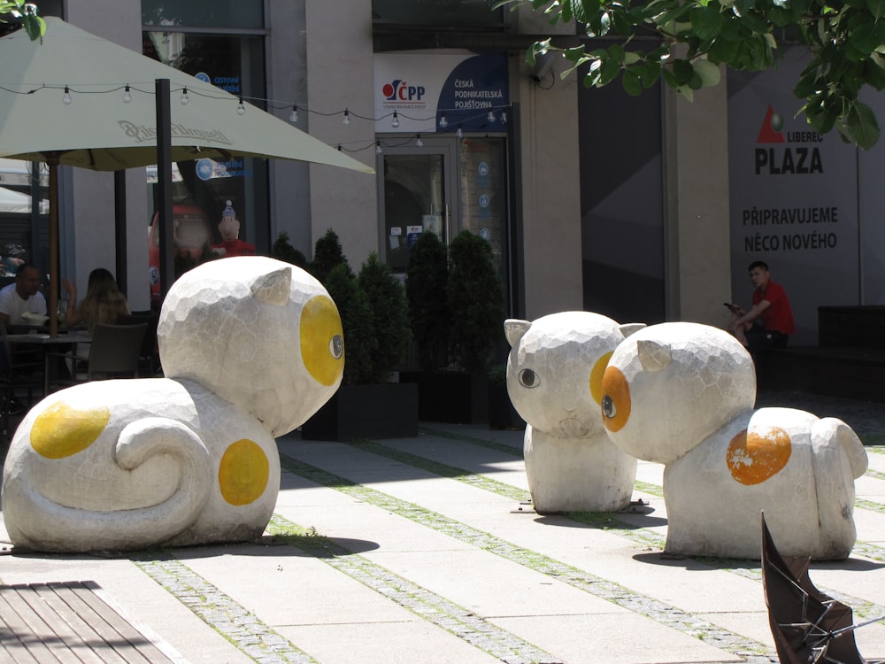 a group of white statues outside a building