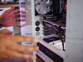 a hand holding a card in front of a computer