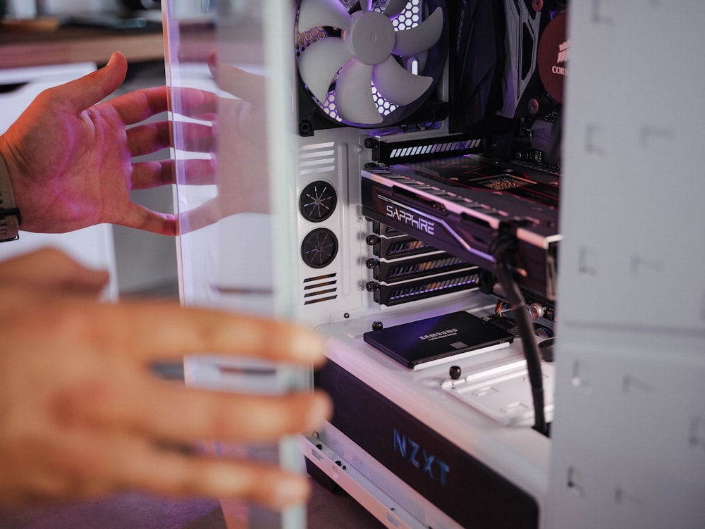 a hand holding a card in front of a computer