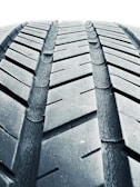 A close-up of a car's tire tread being measured.