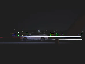 Dynamic Škoda Octavia RS captured in motion on a dark road with subtle light trails.
