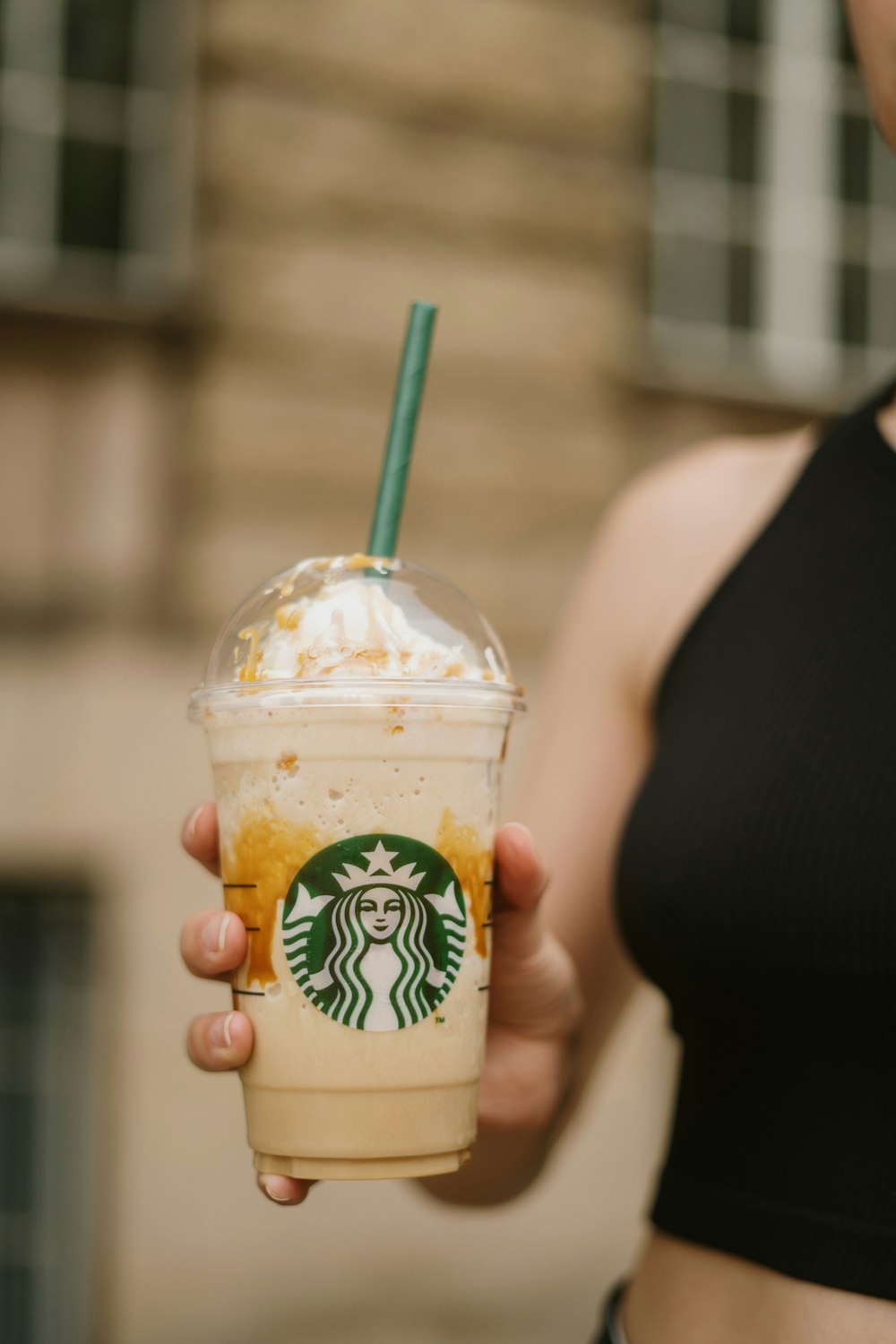 a hand holding a plastic cup with a straw