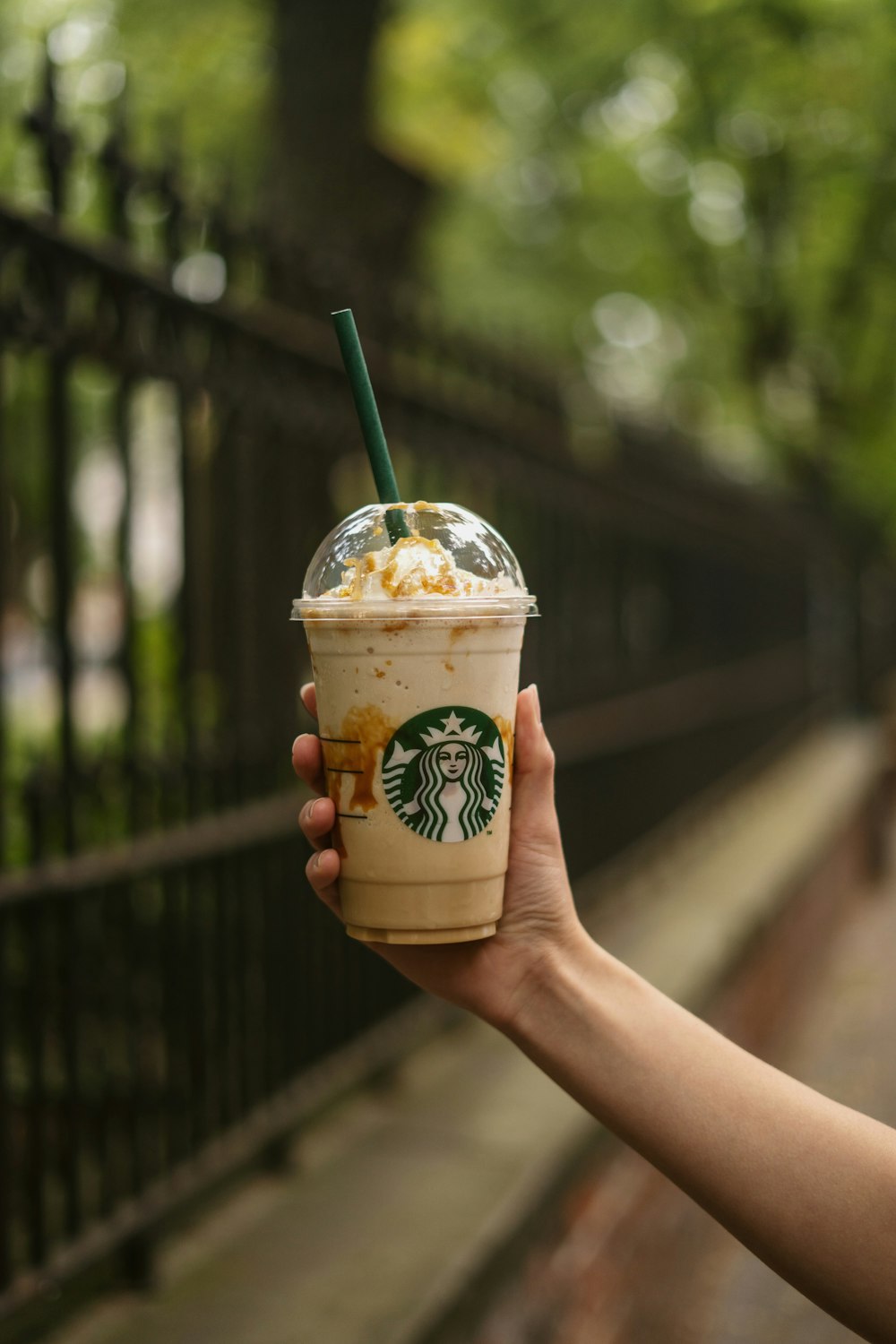 a hand holding a drink with a straw