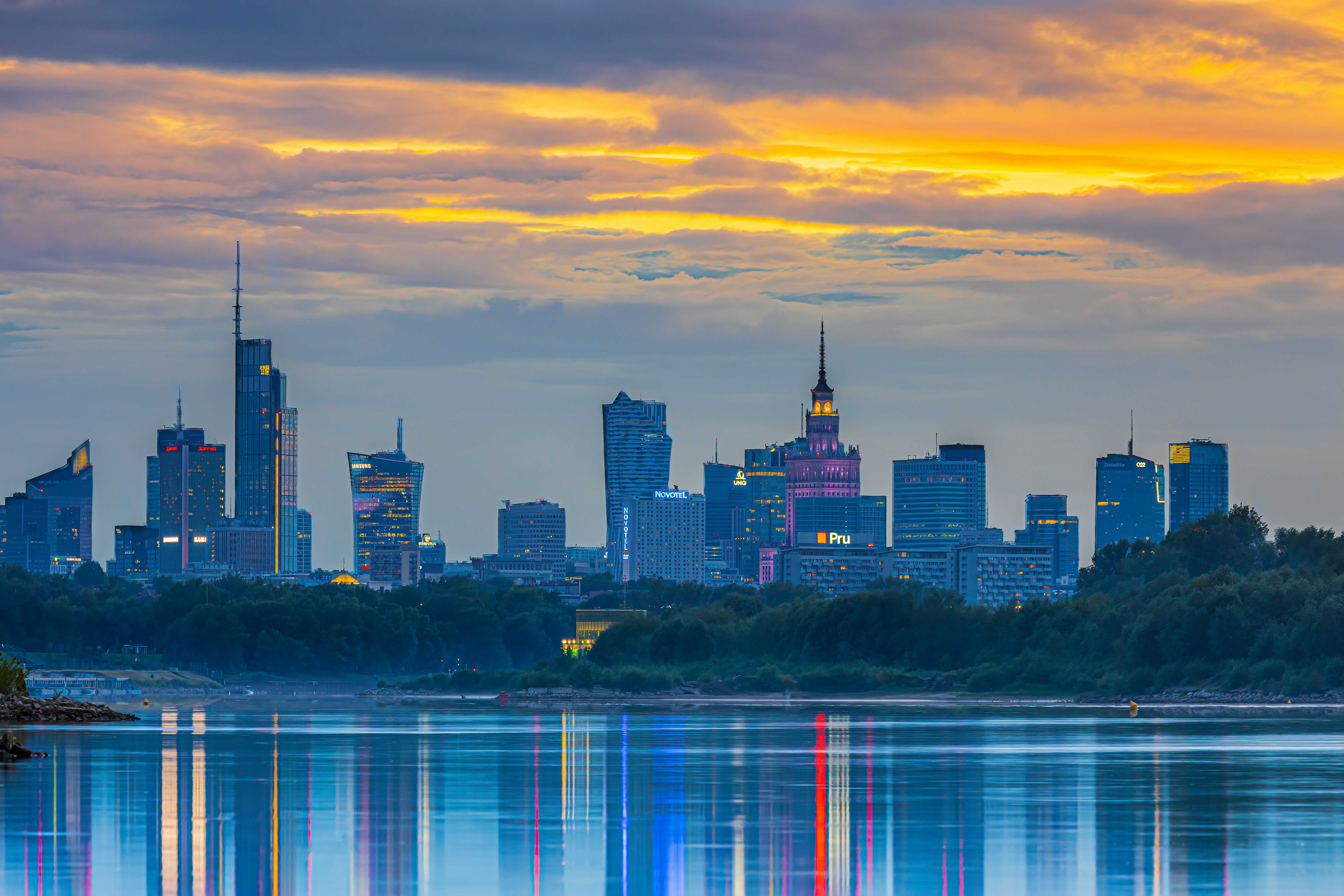 a city skyline with a body of water in front of it