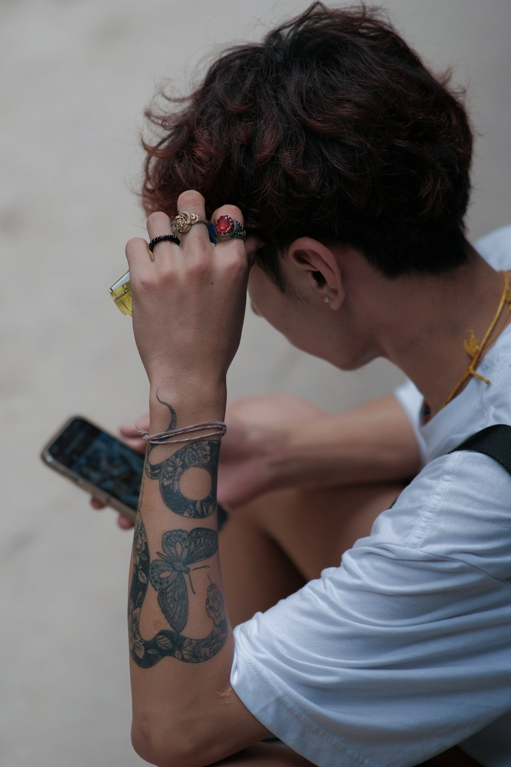 a person with tattoos holding a cell phone