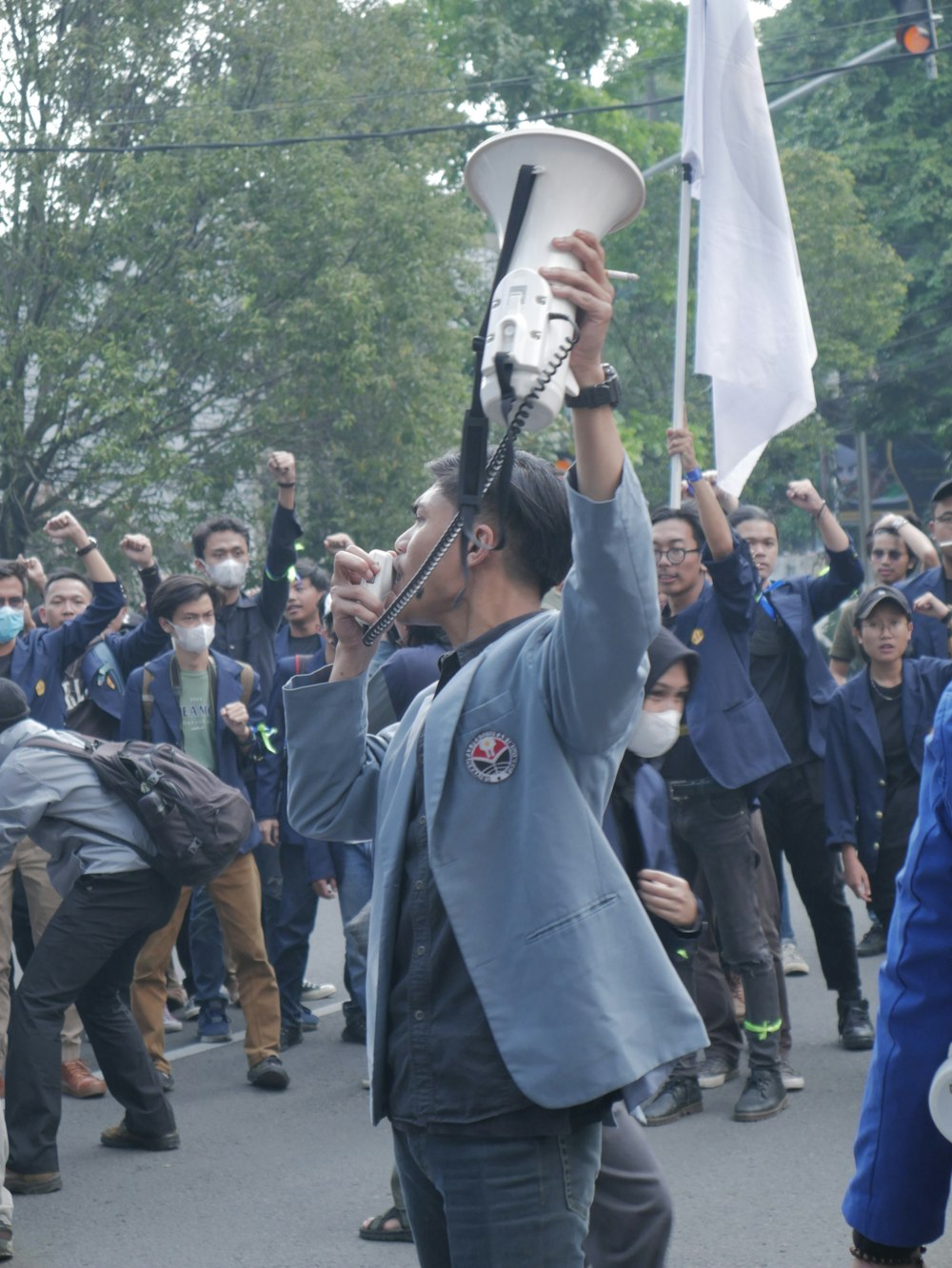 a person holding a megaphone in front of a crowd of people