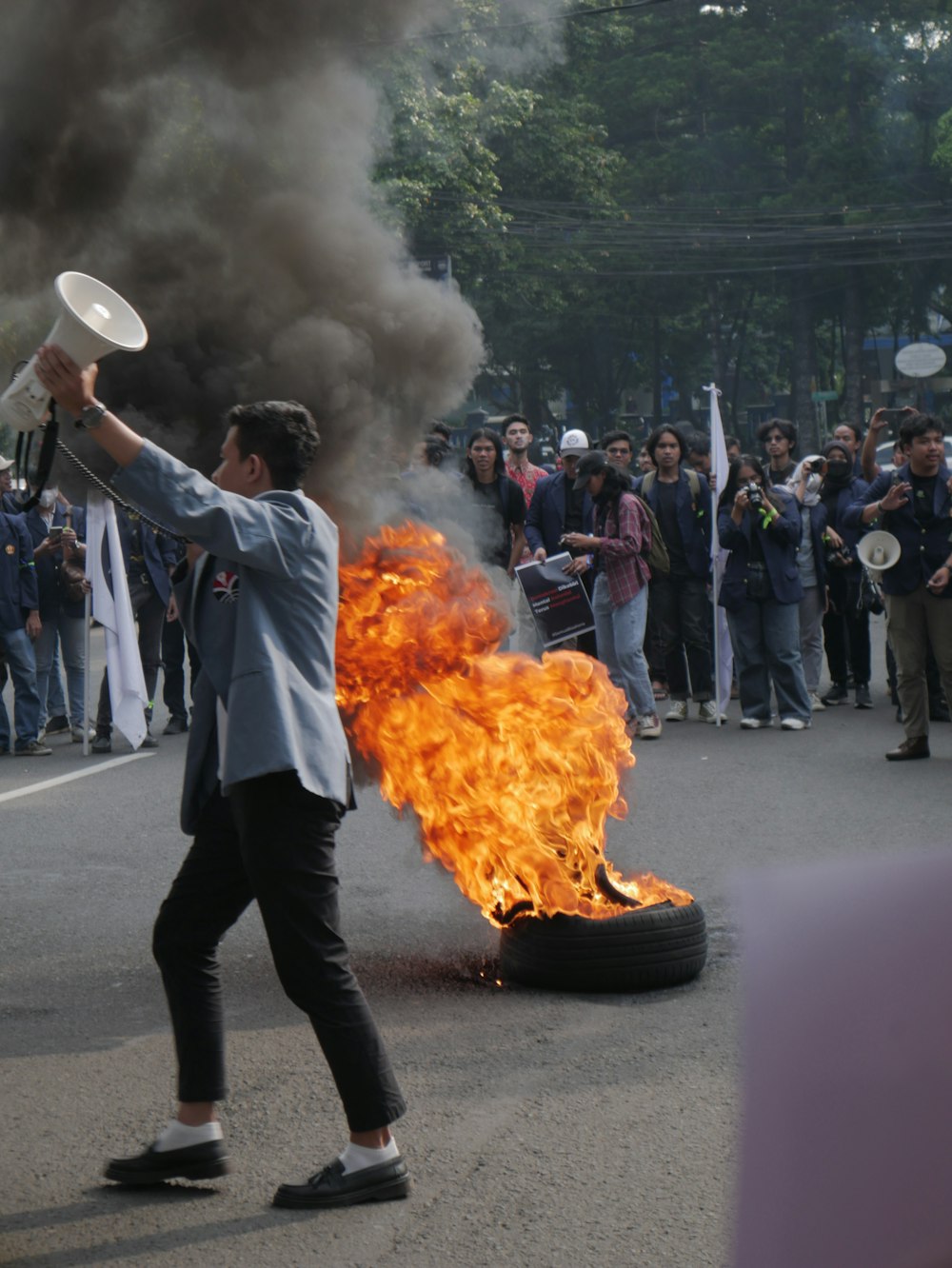 a man holding a white object with flames and a group of people watching