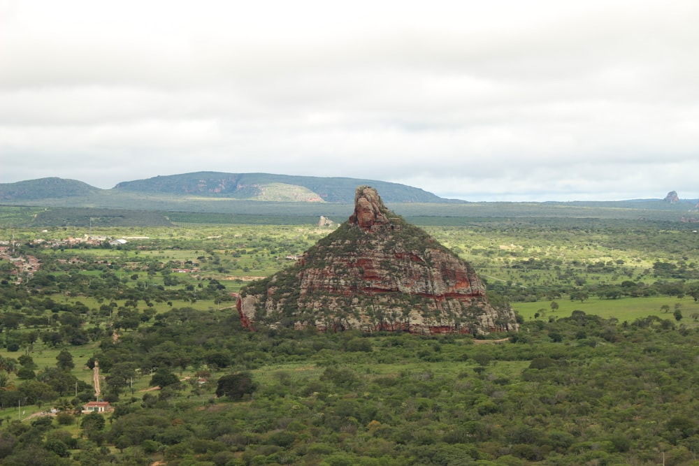 a large rock structure in a green field