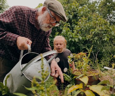 a man and a child looking at a plant