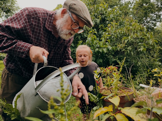 a man and a child looking at a plant