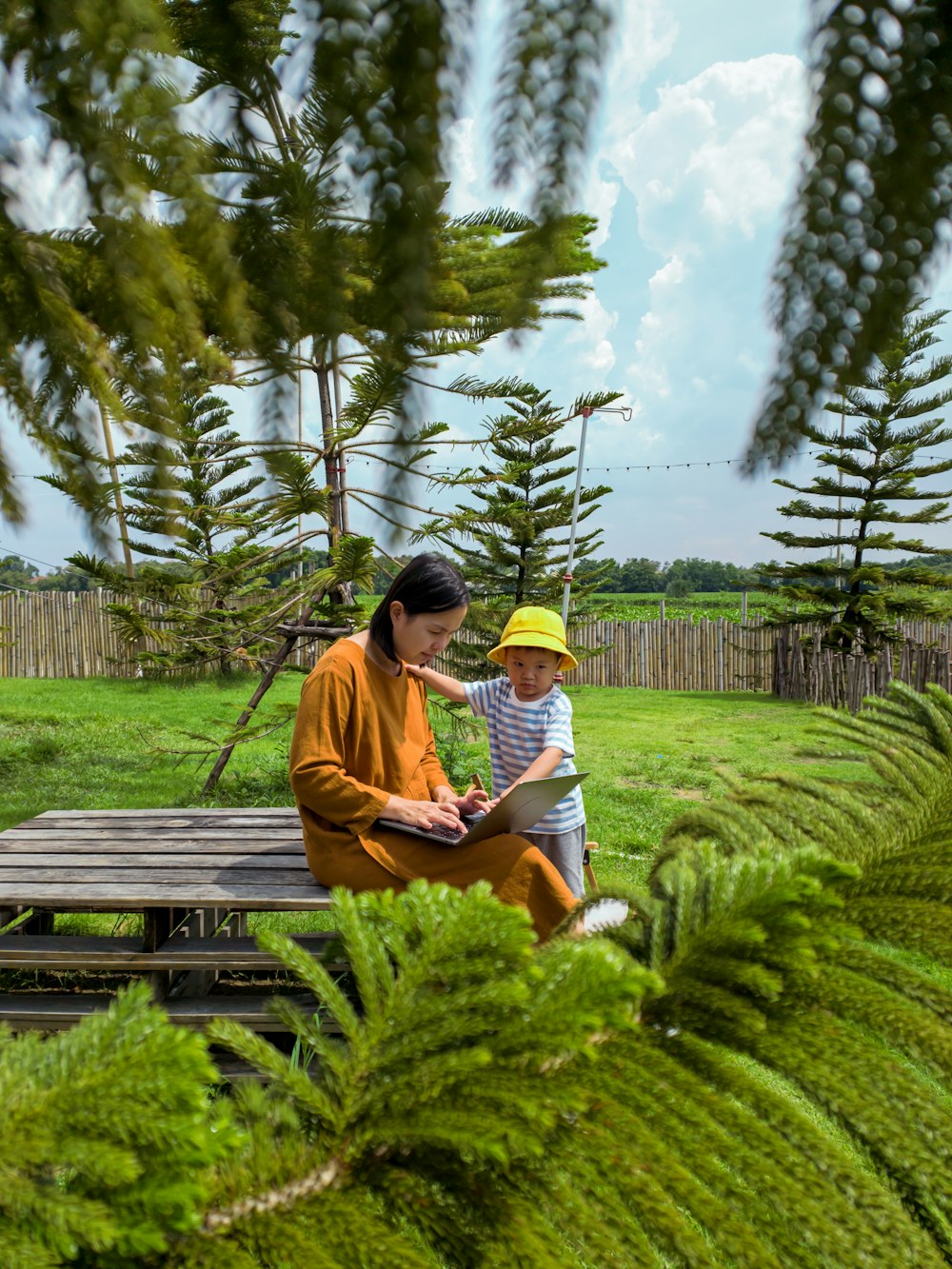 a man and a child sitting on a bench in a garden