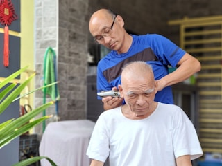 Volunteers providing free haircuts to elderly community members in a cozy community center.