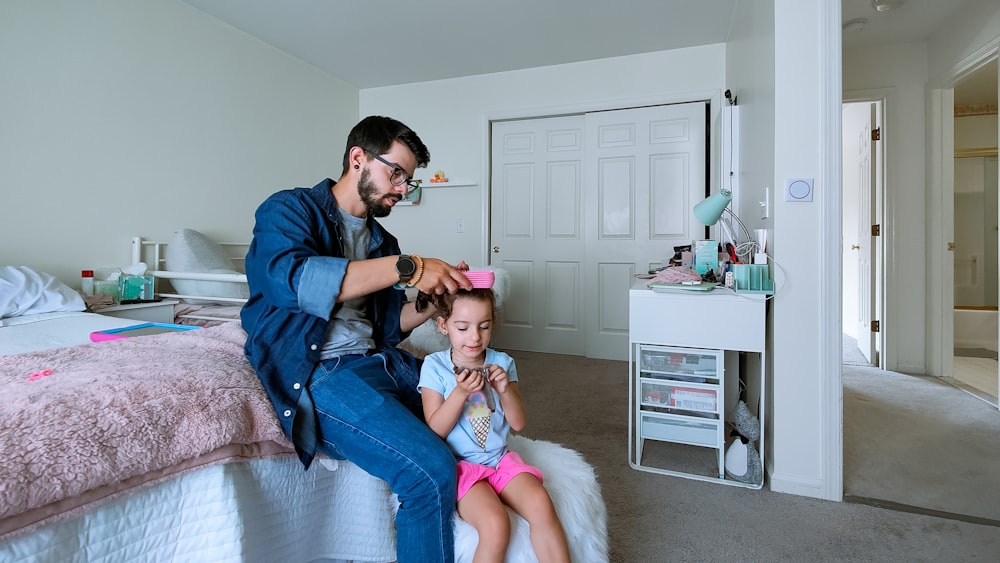 a person and a child sitting on a bed