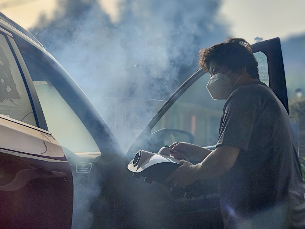 a man in a mask working on a car