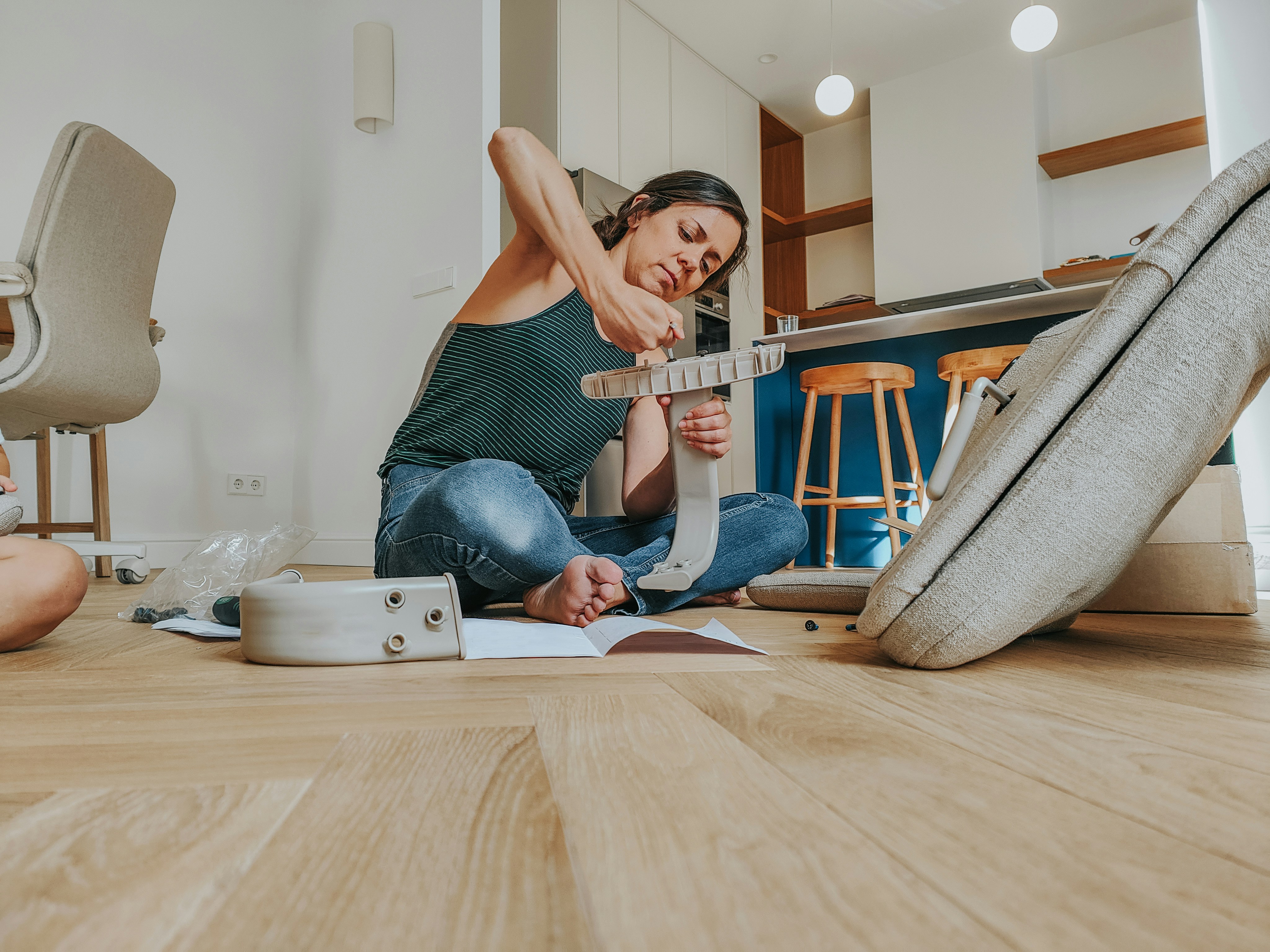 A person using the EasyHome app on a smartphone to check off a home maintenance task in a clean, modern living room.