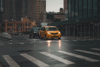 A yellow taxi driving through Erzurum city streets during the day.