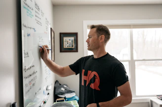 a man writing on a white board