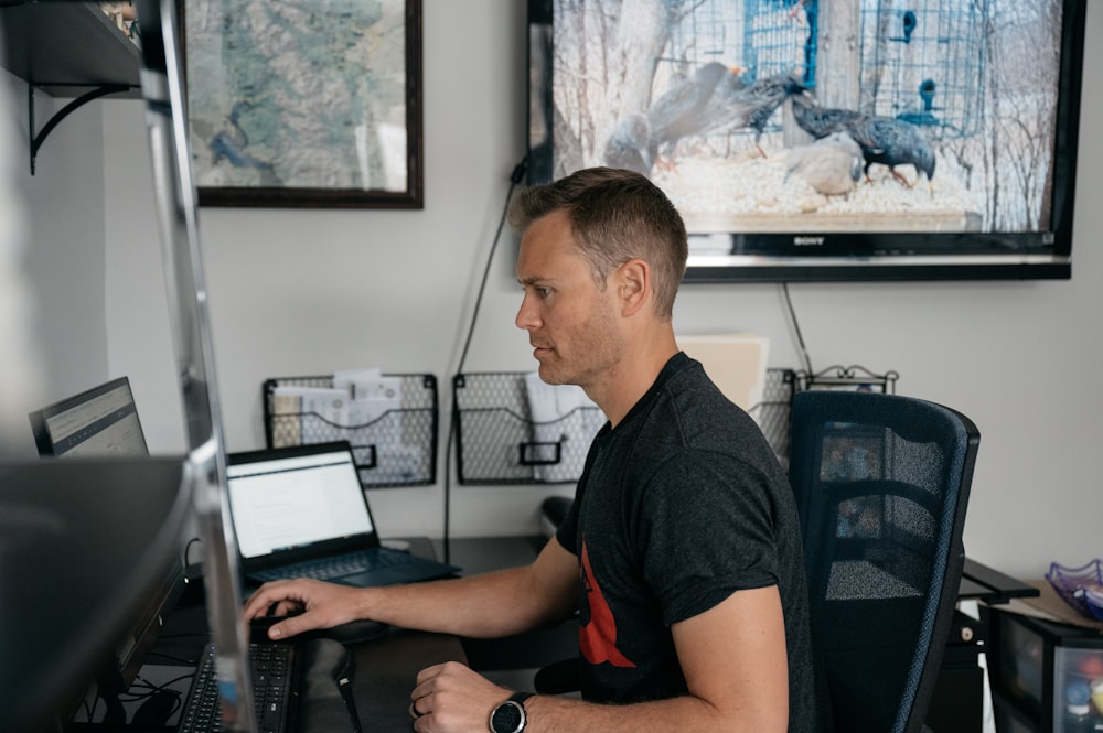 um homem sentado em uma mesa com um computador