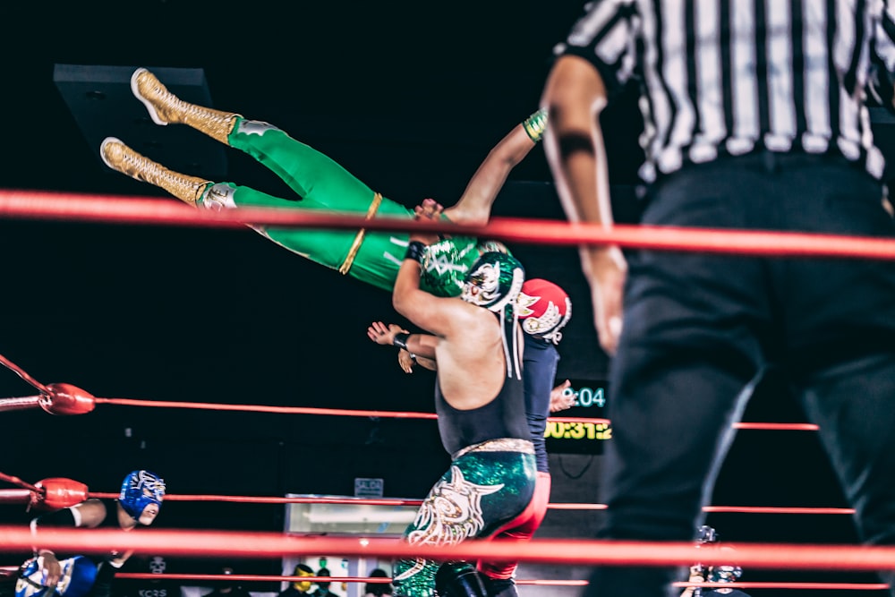 a person holding another man in a ring with a crowd watching